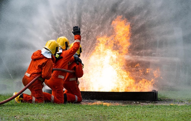 Firefighters or Firemen use extinguisher and spray high pressure water from hose to control fire