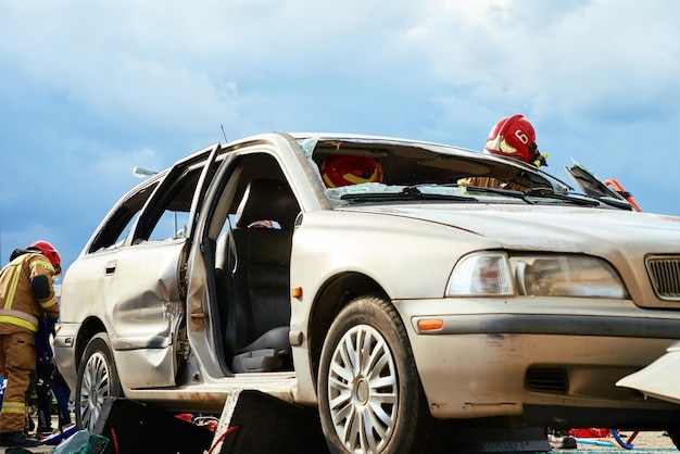 Firefighters during a rescue operation training in broken car