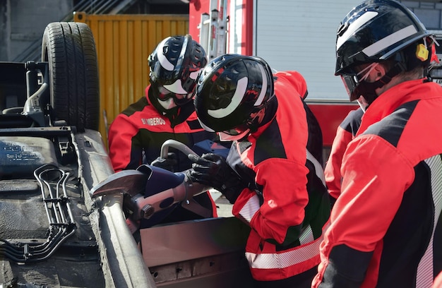 Firefighters rescuing a victim from a car during an accident