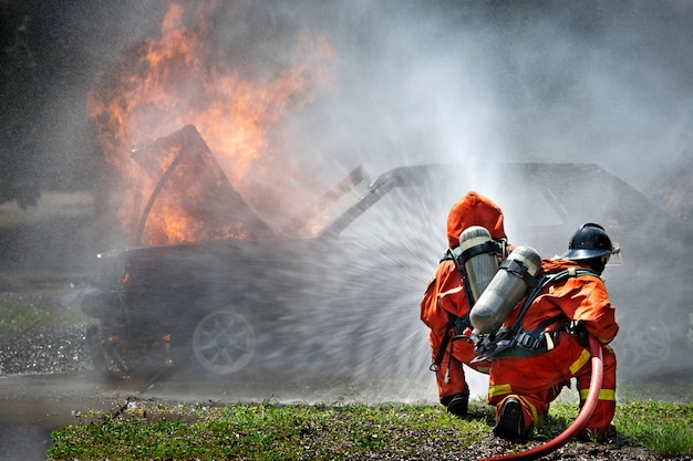 Firemen using extinguisher and water for fighter fire during firefight training. 