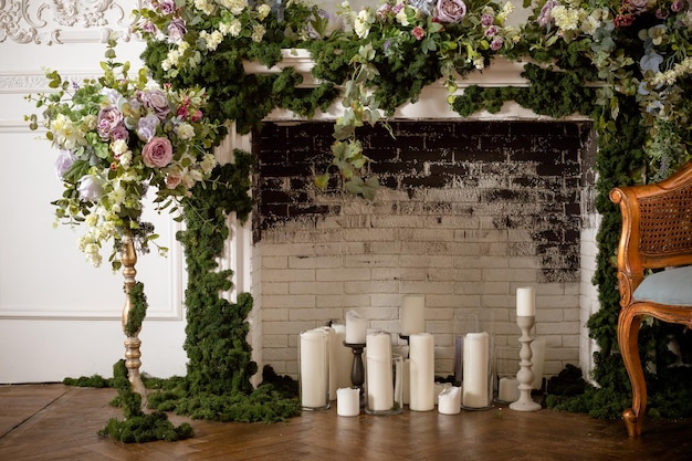 A fireplace with candles and flowers on it