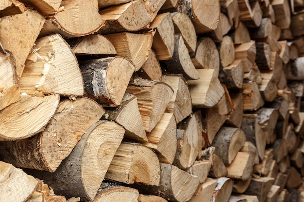 Firewood stacked in the woodpile textured firewood background of chopped wood