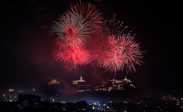 Firework is exploding of over a Buddhist temple on a hill, Thailand