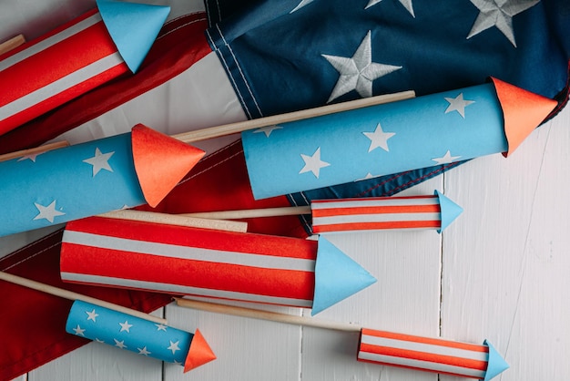 Fireworks and american flag on a white wooden table with place for text 4th july independence day celebration concept