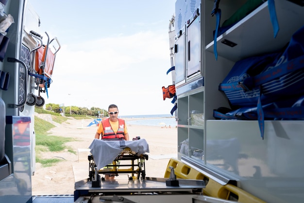 First aid worker using the stretcher of ambulance to work