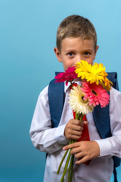 First grader with a backpack holds a bouquet of flowers