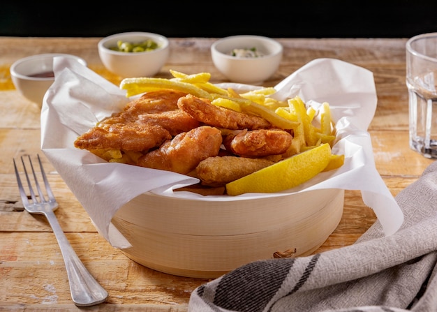 Fish and chips in bowl with sauces