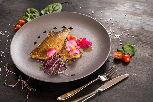 Fish fillet with vegetables on wooden background