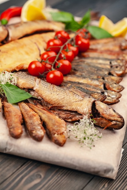 fish grill dish baked whole grilled on a plate with vegetables and lemon