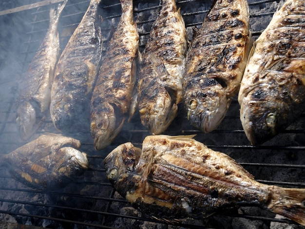 Fish on a grill with smoke coming out of it