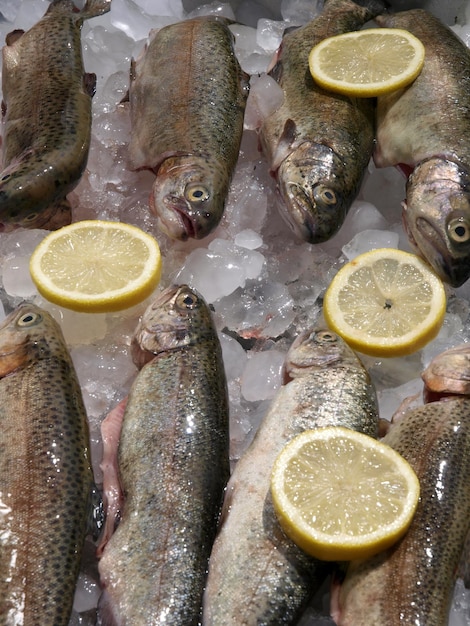 A fish on ice with lemons on it