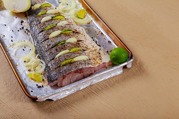 Fish is prepared for marinating raw fish for baking on the fillet with onions