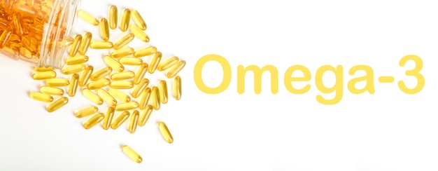 Fish oil in gelatin capsules isolate omega vitamins in golden colored pills on a blank white banner ...