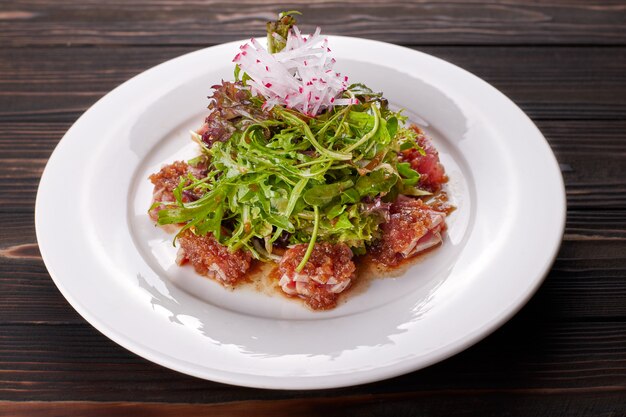 Fish salad. Tuna and rucola. on a white plate