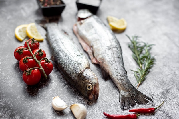 Fish on a table with tomatoes, garlic, and tomatoes