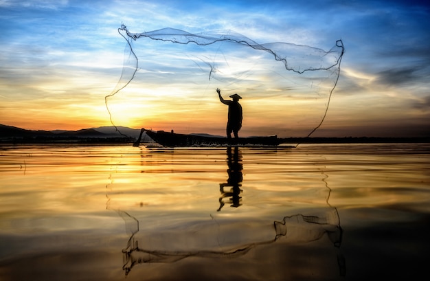 Fisherman in action when fishing in the lake, Thailand