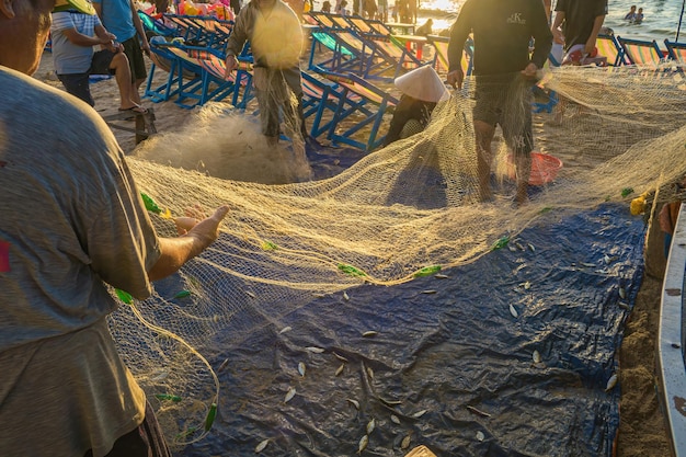 Fisherman casting his net at the sunrise or sunset Traditional fishermen prepare the fishing net Fishermen on beach at the Fishing