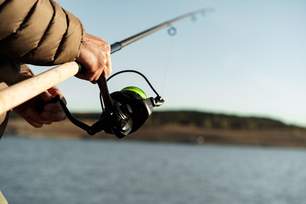 Fisherman hands holding fishing rod close up