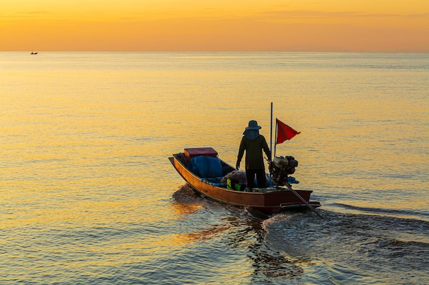 A fisherman is driving a small boat to fish,The fishermen is driving a small fishing boat to park