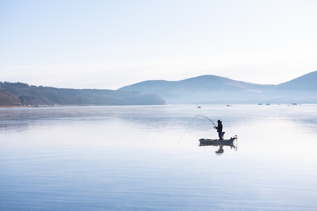 Fisherman on the little boat in lake Yamanaka morning