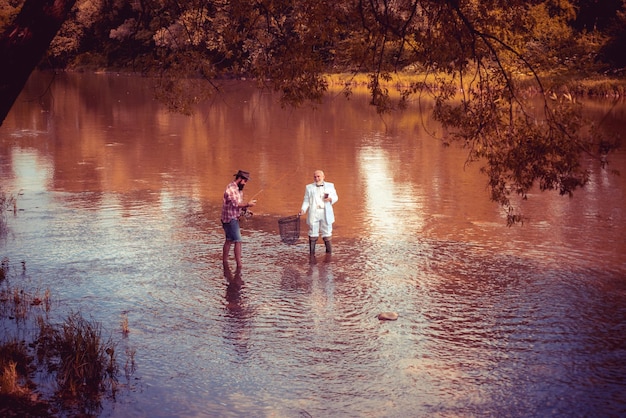 Fisherman man on river or lake with fishing rod