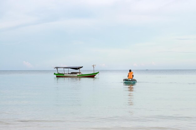 fisherman rowing boat out to sea to catch fish