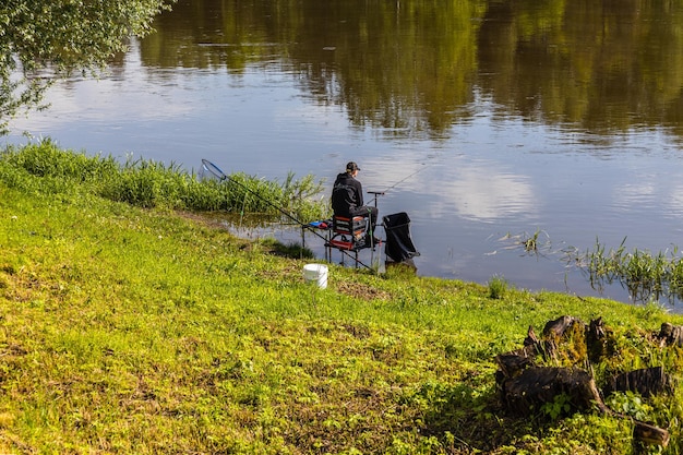 Fisherman sitting by the river on sunny day