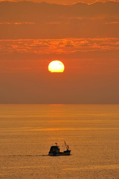 Fishermans boat silhouette at sunset Andaman sea phuket Thailand