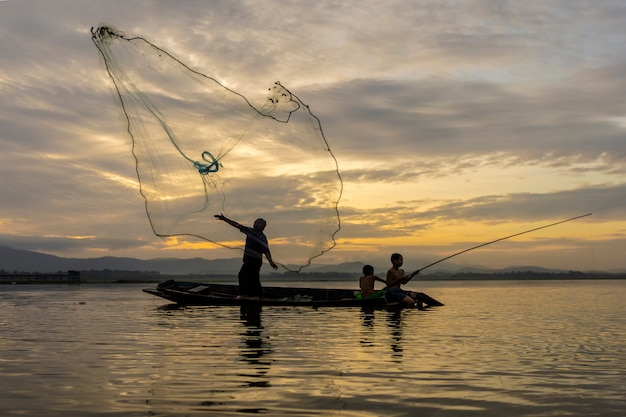 Fishermen Casting are going out to fish early in the morning with wooden boats, old lanterns and nets. Concept Fisherman's life style.
