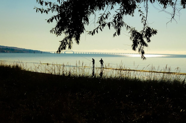 Fishermen on the seashore at dawn.