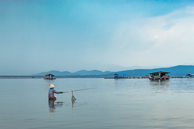 Fishermen sit fishing in the water.