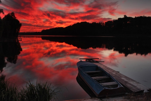 Fishing boat on the lake at sunset Summer landscape