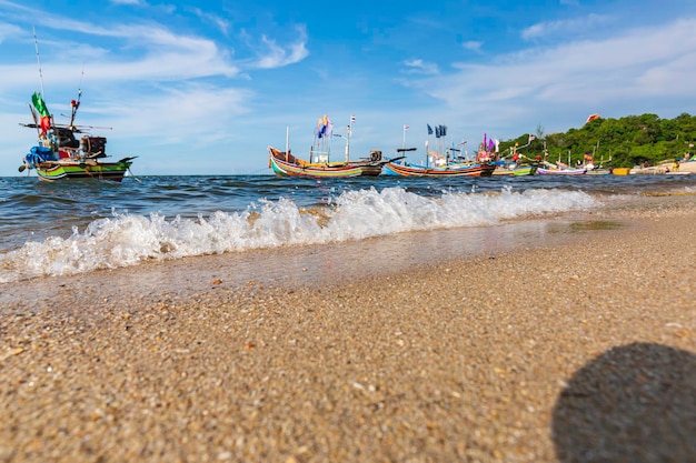 Fishing boat on the sea wave beach with blue sky background