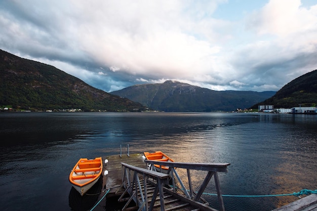 Fishing boat on a still lake in Norway Boat in lake with crystal water in background of mountains