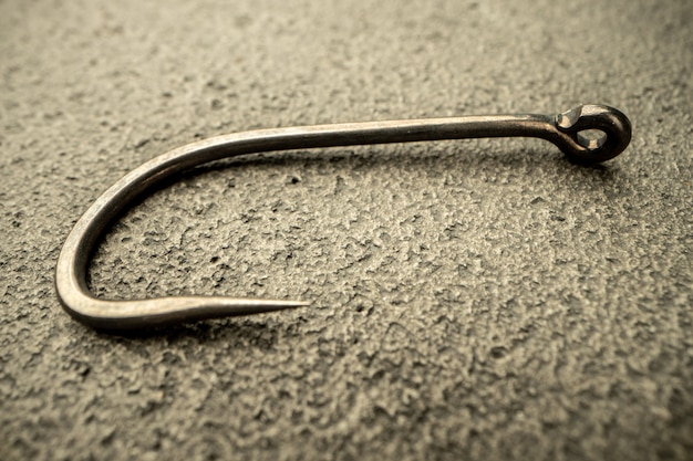 Fishing hooks on concrete textured surface