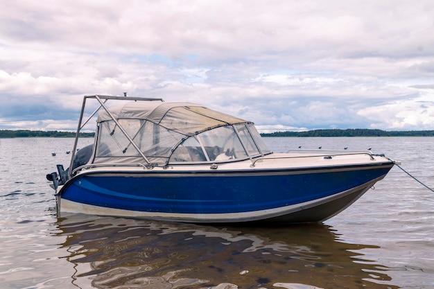 Fishing motor boat standing near the shore on lake boating fishing