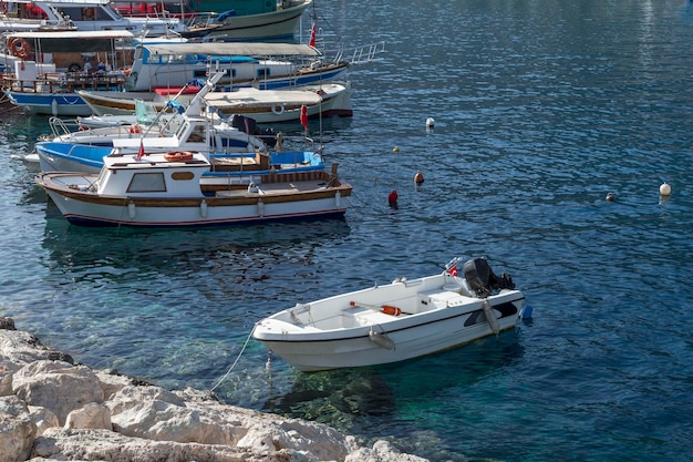 Fishing and pleasure boats are moored at the stone pier Leisure and business at sea on a sunny day