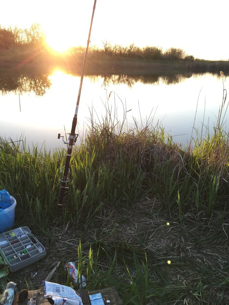 Photo fishing rod at lakeshore during sunset