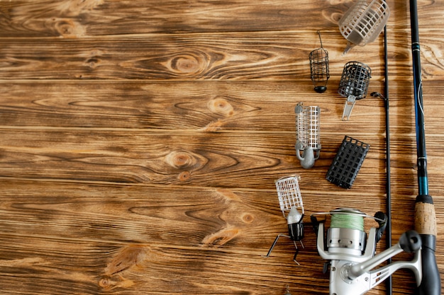 Fishing rod with accessories on wooden table