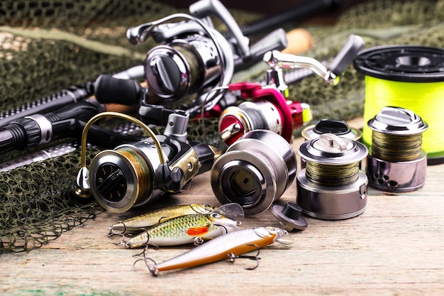 Fishing rods and spinnings in the composition with accessories for fishing on the old surface on the table