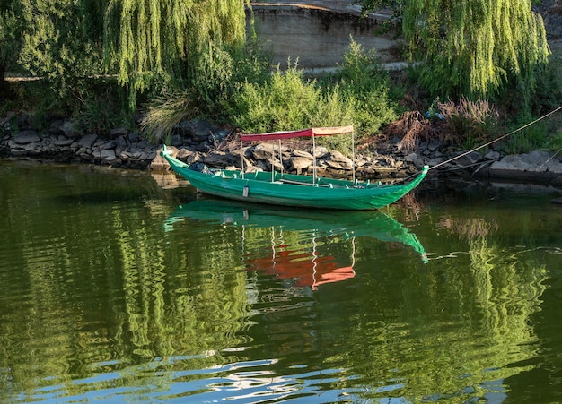 Fishing or rowing boat anchored in the calm waters on the bank of the River Douro in Portugal