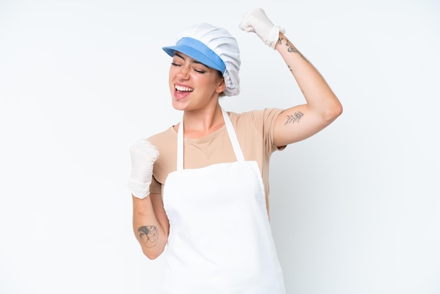 Fishmonger wearing an apron and holding a raw fish isolated on white background celebrating a victory