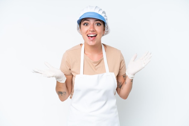 Fishmonger wearing an apron and holding a raw fish isolated on white background with shocked facial expression