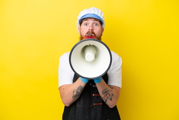 Fishmonger wearing an apron isolated on yellow background shouting through a megaphone