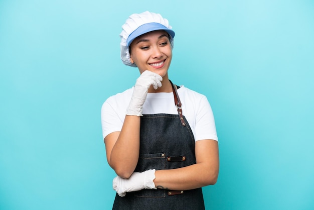 Fishwife Argentinian woman isolated on blue background looking to the side and smiling