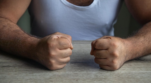 Fists of angry man beats on the table