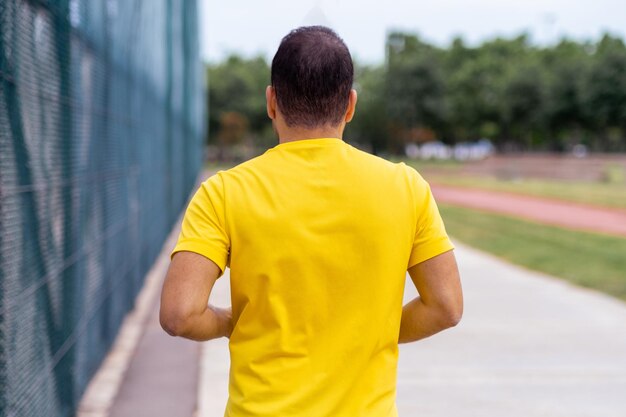 Fit athlete runs along empty urban sports track embracing a healthy lifestyle in a green park