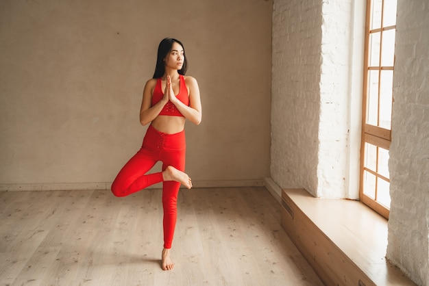 Fit athletic woman doing yoga, self control. Beautiful women working out in gym together