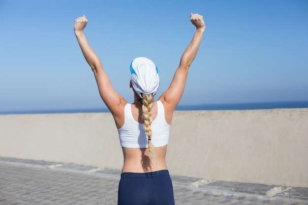 Fit blonde cheering on the pier