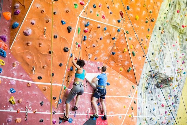 Fit couple rock climbing indoors 